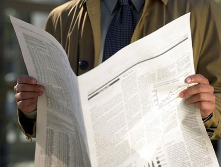 חדשות - איש בז'אקט מחזיק עיתון פתוח בשפה זרה